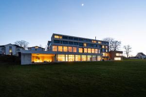 a large building with many windows in a field at Hotel Heiden - Wellness am Bodensee in Heiden