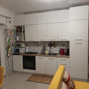 a kitchen with white cabinets and a stove top oven at Hibiscus Apartment Ciampino Rome Roma in Ciampino