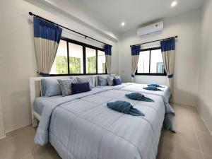 a bedroom with two beds with blue pillows on them at Serene Poolvilla hatyai in Hat Yai +71 photos