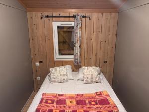 a small bedroom with a bed and a window at Chalet montana 2- 4pers in Roquefeuil +2 photos
