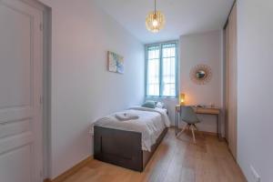 ein Schlafzimmer mit Bett, Schreibtisch und Fenster in der Unterkunft Appartement 2 chambres au coeur de Chambery in Chambéry