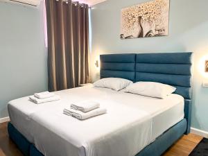 a bedroom with a blue bed with towels on it at Hotel Tier Center in Tirana
