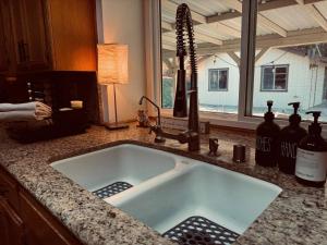 a kitchen sink with bottles of wine on a counter at Magic Sequoia Spacious Home in Three Rivers +113 photos