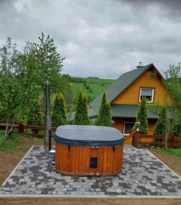 a large wooden tub sitting in front of a house at Bieszczadzki Zakątek 787-899-185 in Bukowiec