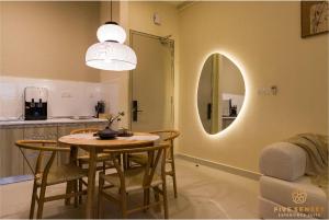ein Esszimmer mit Tisch und Spiegel in der Unterkunft KIP Core Soho Suite by Five Senses in Sepang