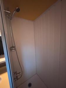 a shower stall with a shower head in a bathroom at Chalet Montana 4 pers in Roquefeuil