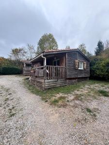 a log cabin with a porch on a gravel road at Chalet Montana pmr 4 pers in Roquefeuil