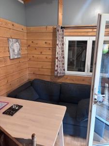 a living room with a couch and a window at Chalet Montana pmr 4 pers in Roquefeuil