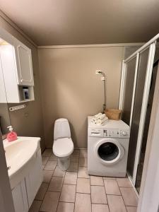 a bathroom with a washing machine and a toilet at Bright and centrally studio with Oceanview in Kristiansand