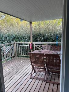 a wooden deck with a wooden table and two chairs at Mobil-home climatisé 4 pers in Roquefeuil