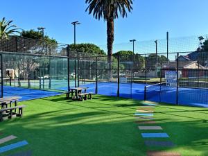 a tennis court with two benches and a tennis courtermott at ANEW Resort Wilderness Garden Route in Wilderness