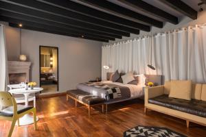 a bedroom with a bed and a table and a couch at Dos Casas Hotel & Spa in San Miguel de Allende