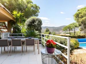 a patio with a table and chairs and a pool at Cabril's Hills Luxe Suites in Cabrils