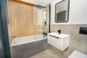 a bathroom with a white sink and a bath tub at Spacious 2 Bedroom Apartment in Central Newark in Newark upon Trent