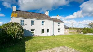 a large white house with a large yard at Trecastell in Rhosneigr