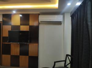 a room with a heater and a tv and a wall at Osma Living Apartment Peshawar in Peshawar