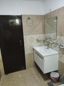 a bathroom with a white sink and a mirror at Osma Living Apartment Peshawar in Peshawar +7 photos