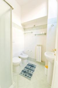 a white bathroom with a toilet and a sink at SanFa Roof in Viterbo