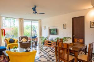 a living room with a table and chairs at Magnolia by Da Alohas El Arbol at Candolim in Nerul