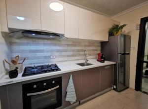 a kitchen with a stove and a sink and a refrigerator at Central Location, Breathtaking Views! in Addis Ababa