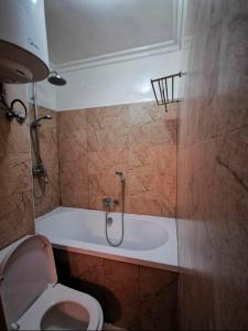 a bathroom with a toilet and a bath tub at Central Location, Breathtaking Views! in Addis Ababa +3 photos