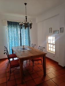 a dining room with a wooden table and chairs at Casa Flow and Glow in Santiago do Cacém +32 photos