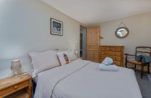 a bedroom with a white bed and a wooden dresser at Près des Forts in Briançon
