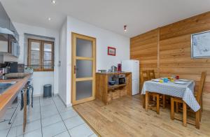 una cucina con tavolo e una cucina con pareti in legno di Près des Forts a Briançon