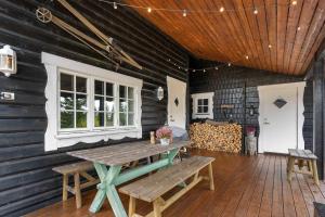 un patio con una mesa de madera y un banco en Fagerasen 208 by Vacation Trysil, en Mælem