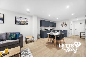 een woonkamer en keuken met een bank en een tafel bij The Old Schoolhouse in Leeds