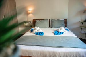 a bed with two stuffed animals on top of it at Bluewave Apartment in Pyla