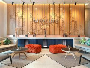 a lobby with a waiting area with couches and tables at Mercure Samarinda in Samarinda