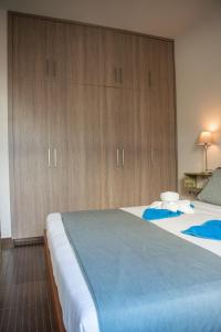 a bedroom with two beds and wooden cabinets at Bluewave Apartment in Pyla