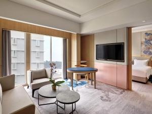 a living room with a couch and a tv at Mercure Samarinda in Samarinda