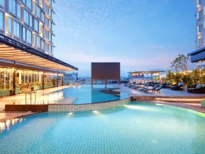 a large swimming pool on the side of a building at Mercure Samarinda in Samarinda +127 photos