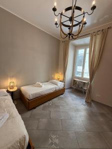 a bedroom with two beds and a chandelier at House - Cesare Balbo - Too in Rome