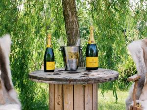 two bottles of wine on top of a wooden table at Poppie's Shepherds Hut at Shepherds Lodge Retreat and Wellness in Nottingham +44 photos