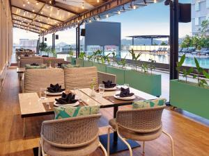 a restaurant with a table and chairs on a balcony at Mercure Samarinda in Samarinda