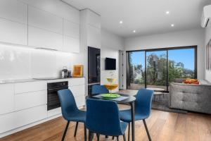 Una cocina y un comedor con mesa y sillas. en Treetop Hideaway - Ohope Holiday home, en Ohope Beach