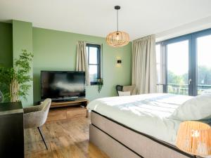 a bedroom with a large bed and a flat screen tv at Polderhuys Goede Hope in Hoofdplaat
