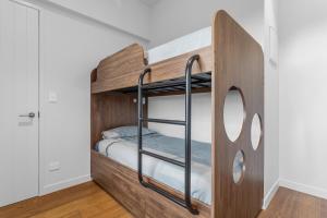 Litera en habitación con paredes blancas en Treetop Hideaway - Ohope Holiday home, en Ohope Beach