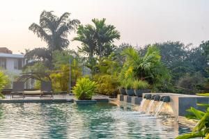 a swimming pool with a fountain in a resort at Magnolia by Da Alohas El Arbol at Candolim in Nerul