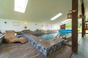 a large swimming pool with a tub in a room at Apartmán Alex, Nezábudka in Tatranska Strba