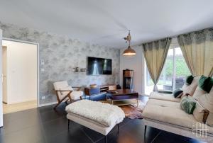 ein Wohnzimmer mit einer Couch und einem Sessel in der Unterkunft La Familial - 6V - Parking - Jardin - Bureau in Montbazon