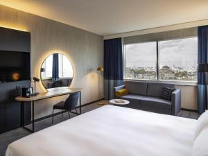 a hotel room with a bed and a desk and a couch at Mercure Antwerp City South in Antwerp