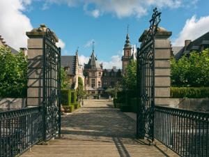 an iron gate to a castle with a building in the background at Kasteel van Ordingen in Sint-Truiden