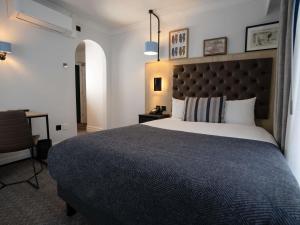 a bedroom with a large bed and a desk at Mercure Oxford Hawkwell House Hotel in Oxford +76 photos