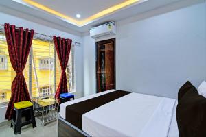 a bedroom with a white bed and a window at Hotel O Top 22 in Ballygunge +25 photos