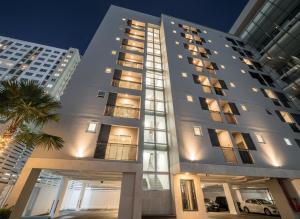 un gran edificio blanco con ventanas y una palmera en UTD8 Hotel and Residence, en Bangkok