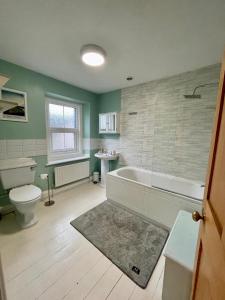 a bathroom with a tub and a toilet and a sink at Charming 3 bedrooms Cottage in Tirril in Tirril